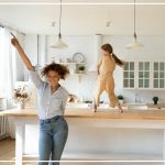Frau und Kind tanzend vor Freude über Hausverkauf